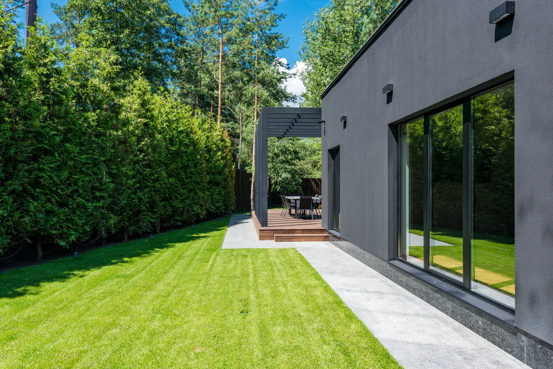 Fachada de una casa contemporánea gris con jardín