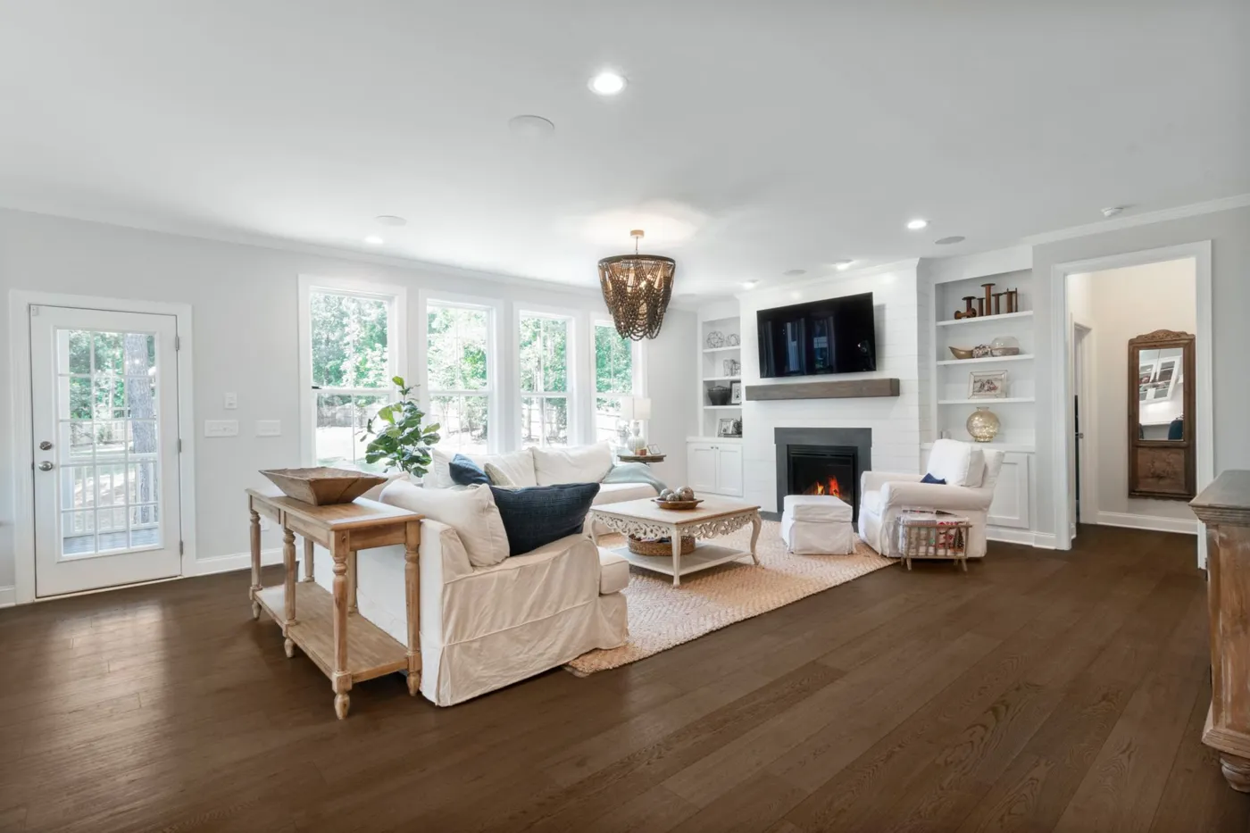 Sala luminosa con sillones blancos y piso de madera